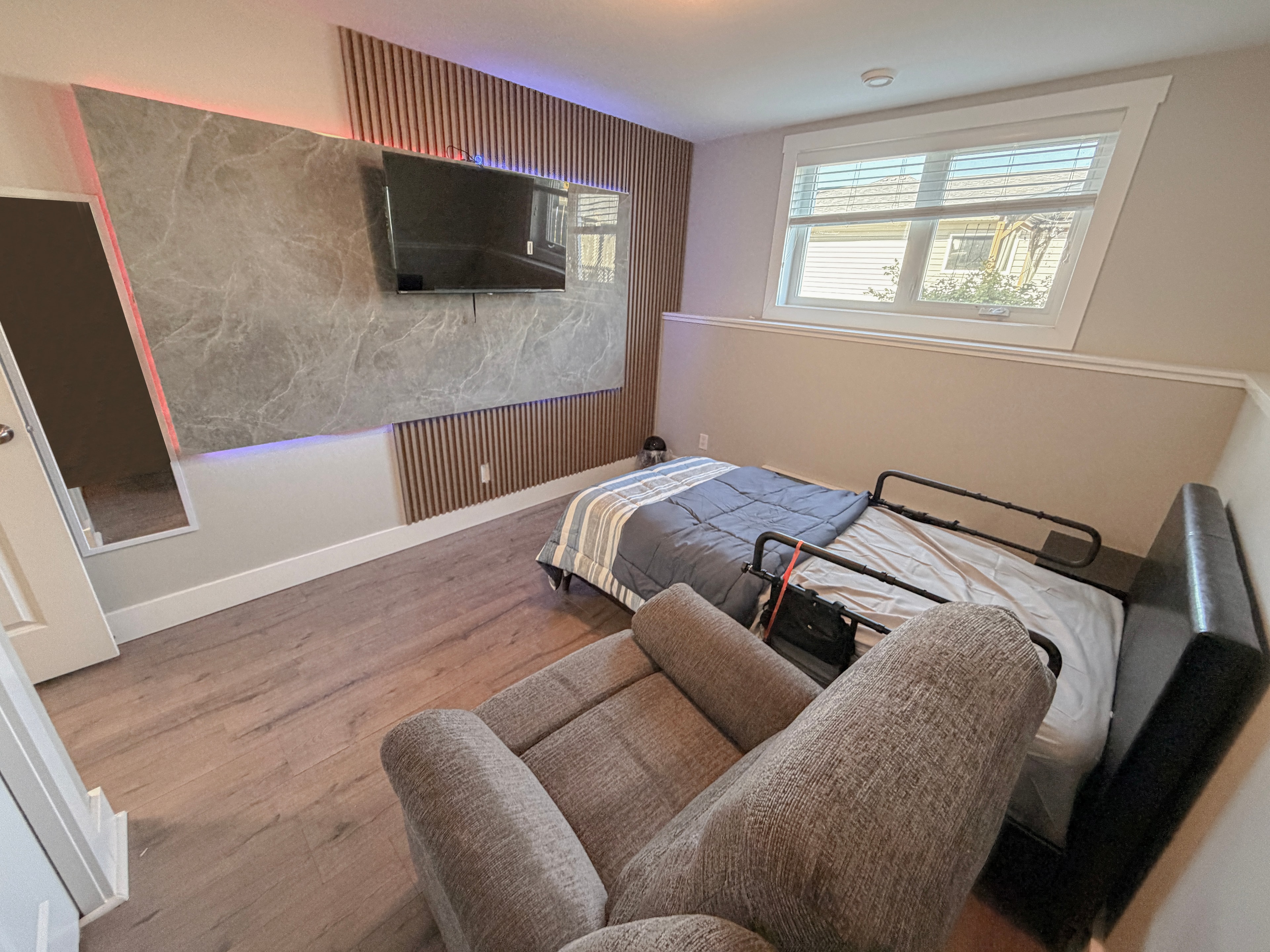 Bedroom with entertainment wall and seating